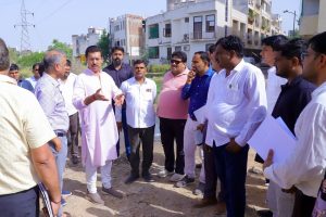 Col. Rajyavardhan Rathore inspecting an underground utility trench and reviewing smart road development work with on-site engineers.