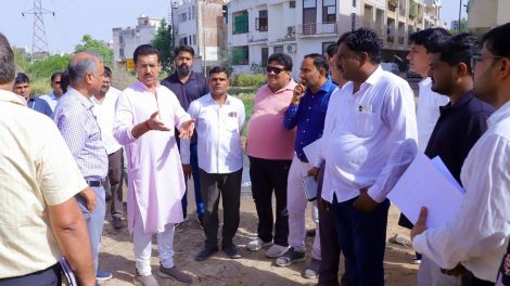 Col. Rajyavardhan Rathore inspecting an underground utility trench and reviewing smart road development work with on-site engineers.