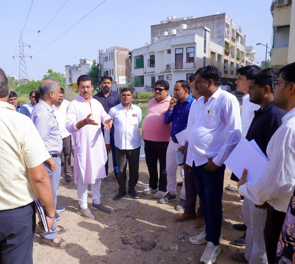 Col. Rajyavardhan Rathore inspecting an underground utility trench and reviewing smart road development work with on-site engineers.