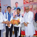 Sports Minister Col. Rajyavardhan Rathore inspiring young village runners and interacting with international coaches during the opening of the 2026 summer camp.