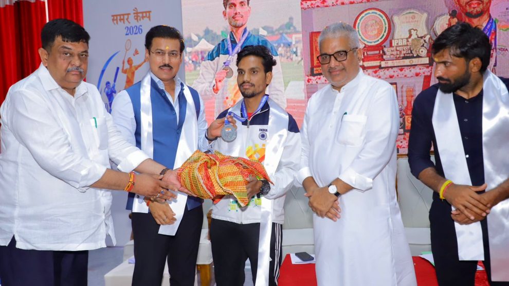Sports Minister Col. Rajyavardhan Rathore inspiring young village runners and interacting with international coaches during the opening of the 2026 summer camp.
