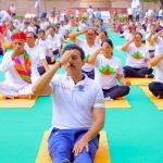 Rajasthan Youth Minister Col. Rajyavardhan Singh Rathore is practicing yoga and speaking on preventative fitness at a public health gathering in Jaipur.